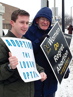 Pastor Dustin Spitler, left, of Vision Baptist Church in Riley, and Ron Marsh of Eastside Baptist Church in Terre Haute hold signs in Terre Haute on Jan. 22 to stand in support of life during the local solemn observance of the Roe v. Wade decision. (Submitted photo by Tom McBroom)