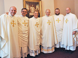 Fathers Andrew and Benjamin Syberg, left, Anthony and John Hollowell and Doug and David Marcotte are all smiles on June 25 in the rectory of SS. Peter and Paul Cathedral in Indianapolis after Father Anthony was ordained a priest. That ordination rounded out three sets of brothers ordained for the Archdiocese of Indianapolis since 2009. (Photo by Sean Gallagher)