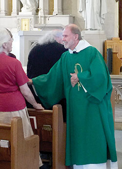 Deacon David Reising greets a person at a Mass at St. Vincent de Paul Church in Bedford. Ordained in 2008, Deacon Reising is involved in many ministries in the Bedford faith community and St. Mary Parish in Mitchell. (Submitted photo)