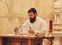 Archdiocesan seminarian Michael Dedek prepares the altar for an Aug. 9 Mass in the Blessed Sacrament Chapel at SS. Peter and Paul Cathedral in Indianapolis. The liturgy was part of the annual end-of-the summer archdiocesan seminarian convocation in which men in priestly formation for the Church in central and southern Indiana spend time together before returning to their respective seminaries. (Photo by Sean Gallagher)