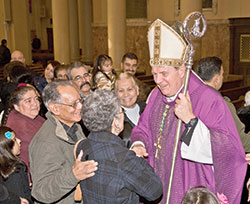 After celebrating Mass at his home parish, Holy Redeemer Church in Detroit, on Nov. 25, 2010, Archbishop Joseph W. Tobin stands in the church’s main aisle greeting parishioners for more than a half-hour. Archbishop Tobin was baptized at the church and was its pastor for several years after being ordained a priest. (File photo by Larry A. Peplin, The Michigan Catholic) 
