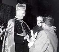 In this undated photo, Cardinal Joseph Ritter greets a father and his young son. (Archive photo) 