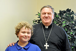 Cardinal Joseph W. Tobin poses with Miles Barth, a seventh-grade student at St. Thomas Aquinas School in Indianapolis, after the young reporter conducted an interview with the cardinal at the Archbishop Edward T. O’Meara Catholic Center in Indianapolis for the school’s newspaper on Dec. 1. (Photo by Natalie Hoefer) 