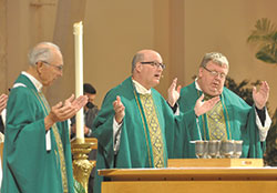 Msgr. William F. Stumpf, center, prays the eucharistic prayer during the Oct. 4, 2015, archdiocesan Respect Life Mass at SS. Peter and Paul Cathedral in Indianapolis. On Jan. 9, he was elected archdiocesan administrator by the priests who make up the archdiocesan college of consultors, and will lead the Church in central and southern Indiana until a new archbishop is appointed. Joining Msgr. Stumpf at the altar are Father Paul Landwerlen, left, and Father Robert Robeson. (File photo by Natalie Hoefer) 