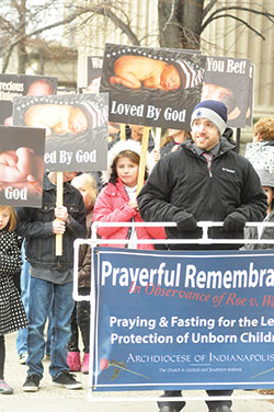 Scott Seibert, marriage and family enrichment coordinator for the archdiocese’s Office of Pro-Life and Family Life, prepares to lead a prayerful march in witness to the call for legal protection of the unborn along Meridian Street in Indianapolis on Jan. 23. (Photo by Natalie Hoefer) 