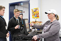 Trey Miller, center, prepares to swipe his identification badge in the lunch line as his mother, Debbie Miller, accepts the charge at Our Lady of Providence Jr./Sr. High School in Clarksville. (Submitted photo)