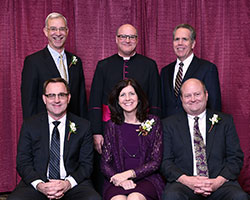 An archdiocesan celebration of Catholic education on Feb. 9 honored four individuals whose Catholic values mark their lives. Sitting, from left, are honorees Kevin Johnson, Kathy Willis and Van Willis. Standing, from left, are honoree Tom Spencer, archdiocesan administrator Msgr. William F. Stumpf and keynote speaker James Danko, president of Butler University in Indianapolis. (Photo by Rob Banayote)