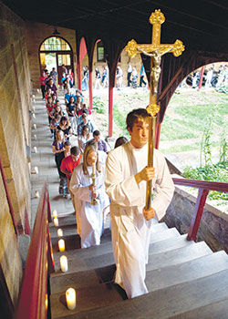 Luke Messmer leads a procession of youths into the Archabbey Church of Our Lady of Einsiedeln in St. Meinrad for a reconciliation service on June 17, 2015. The procession and service were part of One Bread One Cup, a youth liturgical leadership conference of Saint Meinrad Seminary and School of Theology in St. Meinrad. The seminary recently received a $1.38 million grant from the Indianapolis‑based Lilly Endowment, Inc., to help parishes minister more effectively to young adult Catholics. (Photo courtesy of Saint Meinrad Archabbey)
