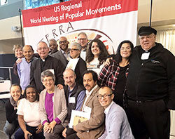 Members of the archdiocesan delegation are pictured with other Indiana delegation members during the Feb. 16-19 World Meeting of Popular Movements regional meeting in Modesto, Calif. Posing from the archdiocese in the front row are: far left, Providence Sister Tracey Horan, a community organizer for Indianapolis Congregation Action Network; fourth from left, Father Christopher Wadelton, pastor of St. Philip Neri Parish in Indianapolis; fifth from left, Juan Perez, a member of Holy Spirit Parish in Indianapolis; and far right, Oscar Castellanos, archdiocesan director of Intercultural Ministry. Back row: fourth from left, Father Kenneth Taylor, pastor of St. Rita and Holy Angels parishes, both in Indianapolis; sixth from left, Araceli Martinez, a member of St. Monica Parish in Indianapolis; and eighth from left, Alma Figueroa, a member of St. Anthony Parish in Indianapolis. Not pictured is Deacon Michael Braun, director of the archdiocesan Secretariat for Pastoral Ministries. (Submitted photo)