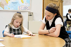 Sixth-grader Chloe Griffin, right, works with first-grader Avery Pierce at St. Gabriel School in Connersville. The school’s sixth-grade students are giving up their recess during Lent to help other students. (Submitted photo)
