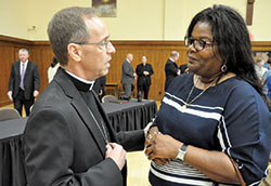 Archbishop-designate Charles C. Thompson speaks with Dabrice Bartet of St. Monica Parish in Indianapolis after his press conference in the Archbishop Edward T. O’Meara Catholic Center in Indianapolis on June 13. (Photo by Sean Gallagher)