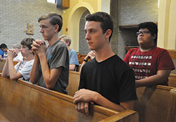 Jacob Sitzman, left, James Mobley, Isaac Williams and Josiah Guerra kneel in prayer during a June 23 Mass during Bishop Bruté Days at Bishop Simon Bruté College Seminary in Indianapolis. Jacob is a member of Nativity of Our Lord Jesus Christ Parish in Indianapolis. James and Isaac are members of St. John the Apostle Parish in Bloomington. Josiah is a member of Holy Trinity Parish in Edinburgh. (Photo by Sean Gallagher)