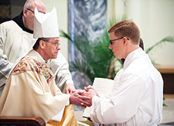 Then-Bishop Charles C. Thompson of Evansville, Ind., ritually holds the hands of archdiocesan seminarian Jeffrey Dufresne during an April 22 Mass in which Dufresne was ordained a transitional deacon. The ordination Mass for Saint Meinrad Seminary and School of Theology was celebrated at the Archabbey Church of Our Lady of Einsiedeln in St. Meinrad. Archbishop Thompson was a seminarian at Saint Meinrad from 1983-87 and was on its faculty from 2002-2011. (Photo courtesy of Saint Meinrad Archabbey)