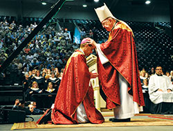 Retired Archbishop Thomas C. Kelly of Louisville ritually lays hands on Father Charles C. Thompson on June 29, 2011, at Roberts Municipal Stadium in Evansville, Ind., during the Mass in which Father Thompson was ordained and installed as the fifth bishop of the Evansville Diocese. (Photo courtesy of Louisville Archdiocesan Archives)