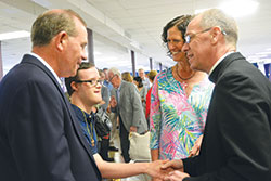 Archbishop Charles C. Thompson shakes hands with Tommy Steiner while the youth’s parents, Bob and Ann, look on. The Steiners, members of Our Lady of Perpetual Help Parish in New Albany, greeted the archbishop at a reception after he celebrated Mass at their parish on July 30. (Photo by Natalie Hoefer)