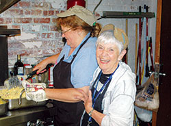 Margie Pike, right, flashes one of her trademark smiles that she has used to welcome and soothe the thousands of people who have been served at the Cathedral Kitchen in Indianapolis during her 11 years of leading the food ministry of SS. Peter and Paul Cathedral Parish in Indianapolis. Here, she shares a moment in the kitchen with Linda Matheis, a volunteer from St. Jude Parish in Indianapolis. (Photo by John Shaughnessy)