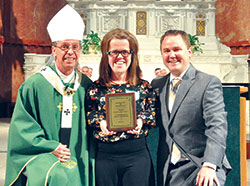 Ashley Barnett of St. Charles Borromeo Parish in Bloomington receives the archdiocese’s 2017 Youth Ministry Servant of the Year Award during a Mass on Sept. 5 at SS. Peter and Paul Cathedral in Indianapolis. She poses for a photo with Archbishop Charles C. Thompson and Scott Williams, the archdiocese’s director of youth ministry. (Photos by John Shaughnessy)