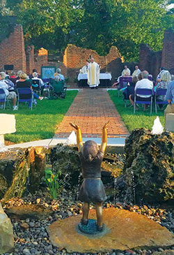 A dedication Mass was celebrated on Sept. 20 marking the opening of Holy Trinity Heritage Park in New Albany. Shown giving a homily during the outdoor liturgy is Father Wilfred “Sonny” Day, pastor of St. John the Baptist Parish in Starlight. The park is located next to St. Elizabeth Catholic Charities’ social services office building, which was once the church rectory. (Submitted photo)