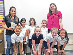 First-grade students in St. Ambrose School in Seymour are all smiles after raising more than $1,500 for classmate Gean Davila’s family impacted by Hurricane Maria in Puerto Rico. Pictured in the front row, from left: Gean Davila, Lily Surface, Sloane Stephens and Isabella Fernandez. Back row: Gean’s mother Belitzabeth Vazquez, Natalie Chavez, Calleigh Fugate, Sam Cutsinger and teacher Amy Hughes. (Submitted photo)
