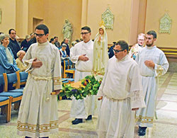 Father Patrick Beidelman, second from right, rector of SS. Peter and Paul Cathedral Parish in Indianapolis, and archdiocesan seminarians process through SS. Peter and Paul Cathedral with a statue of the Blessed Mother during a ‘Morning with Mary’ on Oct. 14. Pictured with Father Beidelman are, front, from left: Liam Hosty and Matthew Perronie. Middle: Michael Clawson and Owen Duckett. (Submitted photo by Bob Kelly)