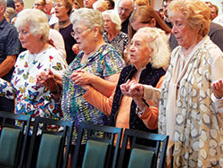Shirley Verhonik, left, Louise David, Mary Harper and Jeanette Clements, all members of St. Joseph Parish, St. Ann’s sister parish in Indianapolis, pray the Our Father during the Oct. 7 centennial Mass. Harper was a longtime member of St. Ann Parish and baptized in its church in 1920. (Photo by Mike Krokos)