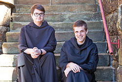 Benedictine Brothers Joel Blaize, left, and Kolbe Wolniakowski sit on the steps of the Archabbey Church of Our Lady of Einsiedeln in St. Meinrad. The two monks of Saint Meinrad Archabbey are the hosts of the “Echoes from the Bell Tower” podcast that features “stories of wit and wisdom from Benedictine monks who live, work and pray in southern Indiana.” (Photo courtesy of Saint Meinrad Archabbey)