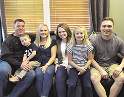 Dave, left, Mason, Holly, Haylee, Riley and Kirk Siegel, all members of St. Nicholas Parish in Ripley County, pose for the camera in their Milan home. Dave, 48, and Holly, 43, adopted half-siblings Mason, 5, and Riley, 8. (Photo by Natalie Hoefer)