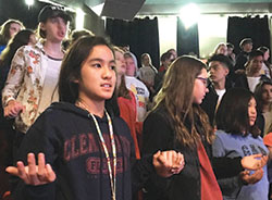 Young members of St. Luke the Evangelist Parish in Indianapolis join hands to pray the Our Father prayer during Holy Fire in Chicago’s UIC Pavilion on Oct. 21. Pictured are Dannielle Le, left, Josie Esposito and Mira Solito. (Submitted photo by Katie Rutter)