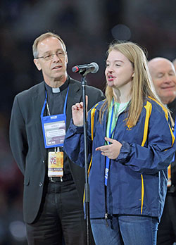 Mia Roberts, a member of the Archdiocesan Youth Council and St. Barnabas Parish in Indianapolis, introduces Archbishop Charles C. Thompson during the Nov. 17 morning session of the National Catholic Youth Conference. (Photo by Bob Nichols)