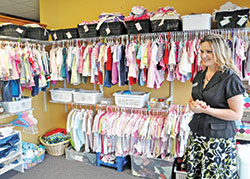 Kristi Potts, executive director of Pregnancy Care Center of Southeast Indiana in Lawrenceburg, discusses the agency’s baby store of donated items, where young women can earn credit for the store by completing educational sessions. (Photo by Natalie Hoefer)