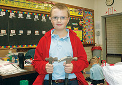 Seventh-grader John Meer can be seen at St. Louis School in Batesville with his tool kit, including a hammer or two, as he selflessly serves the school community taking care of repairs. (Photo by John Shaughnessy)