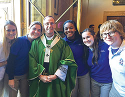 Following the annual Mass for archdiocesan high school seniors on Nov. 29, Archbishop Charles C. Thompson stands by the center doors of SS. Peter and Paul Cathedral in Indianapolis, greeting, shaking hands and posing for photos with seniors from Catholic schools across the archdiocese. Here, he smiles for a group photo with seniors from Bishop Chatard High School in Indianapolis: Erika Campbell, left, Rosemary Butler, Payten Morris, Rachel Doyle and Allan Schneider. (Submitted photo)