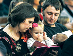 Kellye and Keith Echternach, with their children, Leona, left, and Clara listen during a Jan. 22 Mass at St. John the Evangelist Church in Indianapolis that began a series of events for the inaugural Indiana March for Life. The Echternachs are members of St. John the Evangelist Parish. (Photo by Sean Gallagher)