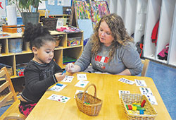 Teacher Heather Keeney helps Ja’Niyla McFerson learn numbers on Jan. 10 in the Kids Care pre­kindergarten program at St. Lawrence School in Indianapolis. (Photo by Sean Gallagher)