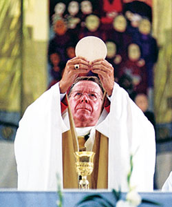 Then-Archbishop Daniel M. Buechlein elevates the Eucharist during a Sept. 16, 2000, Mass in the RCA Dome in Indianapolis to celebrate the jubilee year. More than 30,000 Catholics participated in the Mass. (File photo)