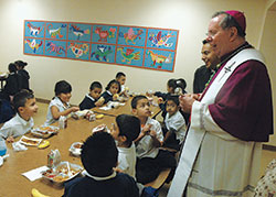 Archbishop Daniel M. Buechlein laughs while chatting with members of St. Philip Neri School’s kindergarten class on Oct. 20, 2009. He visited the school that day to bless it after major renovations had been completed. (File photo by Sean Gallagher)