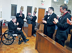 Archbishop Daniel M. Buechlein gives a thumbs up to the seminarians and guests who applaud him after an April 21, 2013, prayer service at Bishop Simon Bruté College Seminary in Indianapolis. The retired archbishop was honored after the service for founding the seminary in 2004. (File photo by Sean Gallagher)