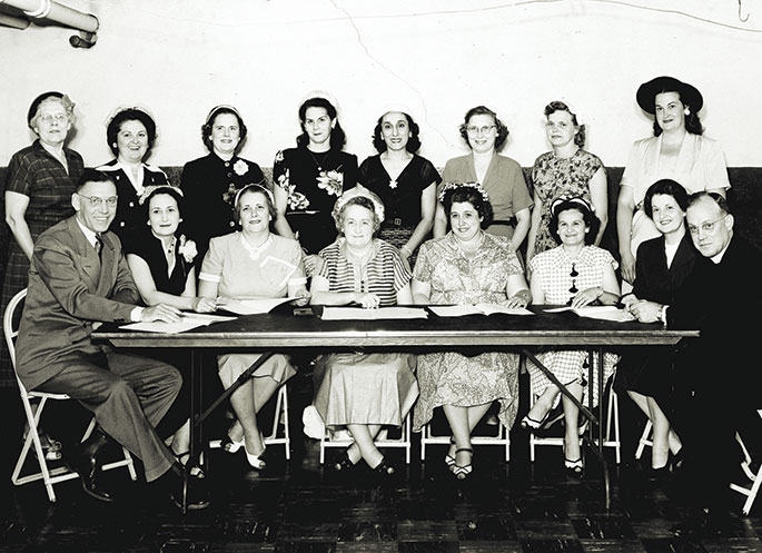 This photo shows the church dedication program committee for the former St. Ann Parish in Terre Haute in 1953. St. Ann Parish was founded in 1876 and had occupied a number of different church buildings. From 1906 to 1953, their parish was served by a building which housed a school on the first floor and the church on the second floor. On Nov. 1, 1952, the parish broke ground for a new church building, which was dedicated on June 21, 1953. St. Ann Parish closed in 2012 as part of the “Connected in the Spirit” planning process.
