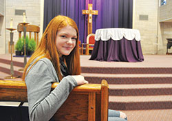 Elizabeth Werner, a freshman at Indiana University (IU) in Bloomington, sits on Feb. 15 in the church of St. Paul Catholic Center in Bloomington. Werner’s faith has grown over her first year at IU through the increasing campus ministry efforts sponsored by St. Paul and missionaries from the Fellowship of Catholic University Students. (Photo by Sean Gallagher)