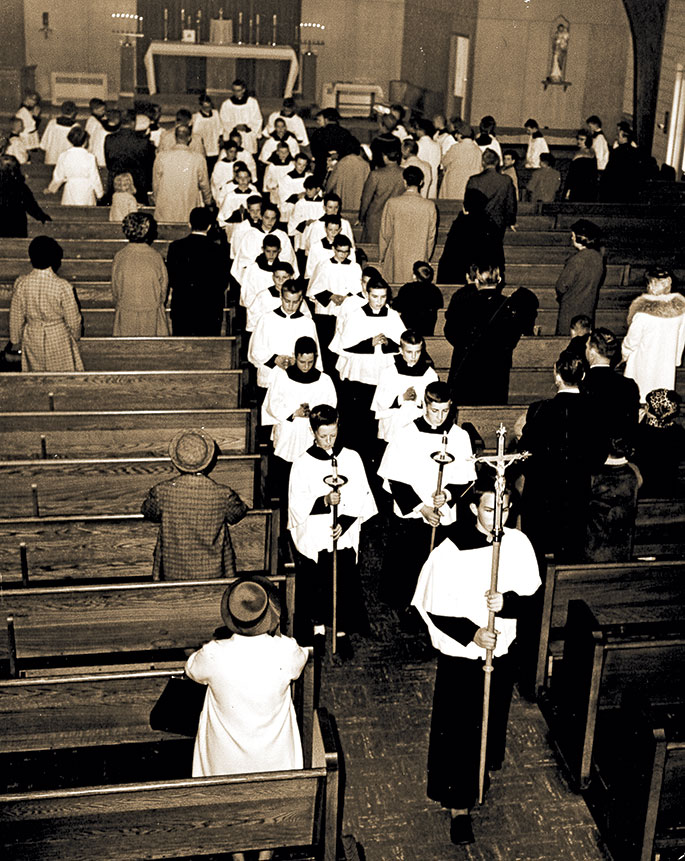 This photo was taken at the conclusion of an altar server investiture ceremony at St. Matthew the Apostle Church in Indianapolis on March 8, 1964. The new altar servers were in grades 5 through 8 in the Indianapolis North Deanery faith community’s school. Appearing nearest to the altar in the recessional line is St. Matthew’s pastor, Father Andrew Diezeman. The ceremony was sponsored by the Serra Club of Indianapolis, which works to foster priestly and religious vocations.