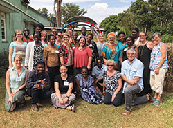 Sarah Turo-Shields, center in the red shirt, poses with the staff and participants of the Trauma Healing Facilitation training workshop that the 18-year-old St. Barnabas member attended while spending a missionary gap year in Uganda. (Submitted photo)