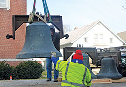 Workmen from The Verdin Company in Cincinnati lower onto a flatbed truck the largest bell—weighing 1,800 pounds—from the former Holy Trinity Church in Indianapolis on March 14. The three bells from the Slovenian-founded parish, which was merged in 2014, will be cleaned and eventually moved to St. Malachy Parish in Brownsburg. (Photos by Natalie Hoefer)