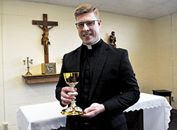 Standing on May 16 in the St. Alphonsus Liguori Chapel in the Archbishop Edward T. O’Meara Catholic Center in Indianapolis, transitional Deacon Jeffrey Dufresne holds a chalice he received from the archdiocesan archives that he will use in the celebration of the Eucharist after he is ordained a priest at 10 a.m. on June 2 in SS. Peter and Paul Cathedral in Indianapolis. The liturgy is open to the public. (Photo by Sean Gallagher)