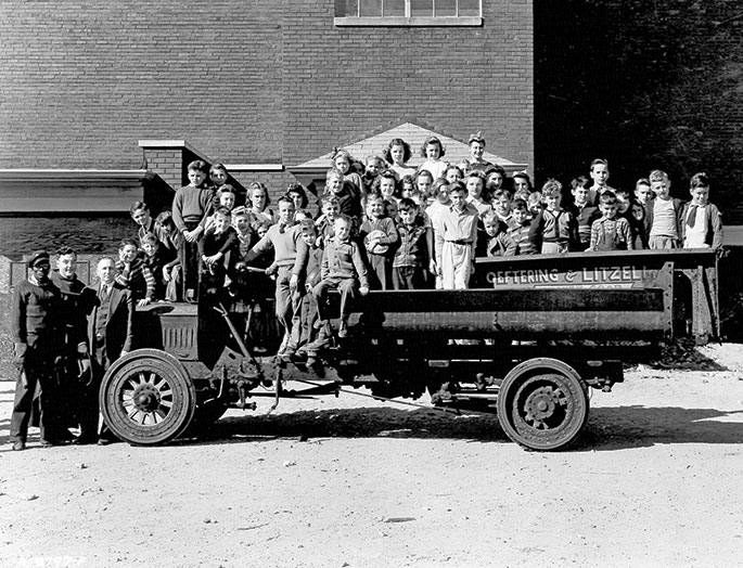 This photo depicts children at St. Roch Parish in Indianapolis aboard a coal truck that was donated to the parish school for a scrap metal drive in October 1942. The truck was donated to St. Roch by the Oeftering-Litzelman Coal Company. The caption accompanying the original photograph, which was published in The Indianapolis News, states that the truck weighed 8,275 pounds, and that a total of 19,000 pounds of scrap metal were collected. The purpose of the scrap metal drive was to purchase new equipment for the school library. 