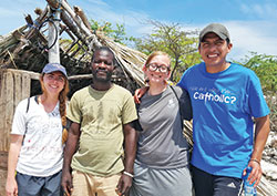 Hoping to make a difference in the world is one of the defining qualities of young adult Catholics. Here, three members of St. John the Evangelist Parish in Indianapolis pose for a photo with a resident of Haiti, second from left, during a service trip to that Caribbean country in 2017. The St. John members are Meghan McCann, left, Alexandra Makris and Homero Santiago Valladares. (Submitted photo)