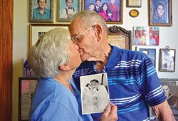 In their home in Waldron on Aug. 2, Carolyn and Omer Weintraut recreate the pose they struck on their wedding day on Aug. 1, 1953. The members of St. Vincent de Paul Parish in Shelby County recently celebrated their 65th wedding anniversary. (Photo by Natalie Hoefer)