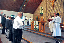 Archbishop Charles C. Thompson blesses new seminarians for the Archdiocese of Indianapolis during an Aug. 7 Mass at the chapel of Our Lady of Fatima Retreat House in Indianapolis. The Mass was part of the annual convocation of archdiocesan seminarians. (Photo by Sean Gallagher)