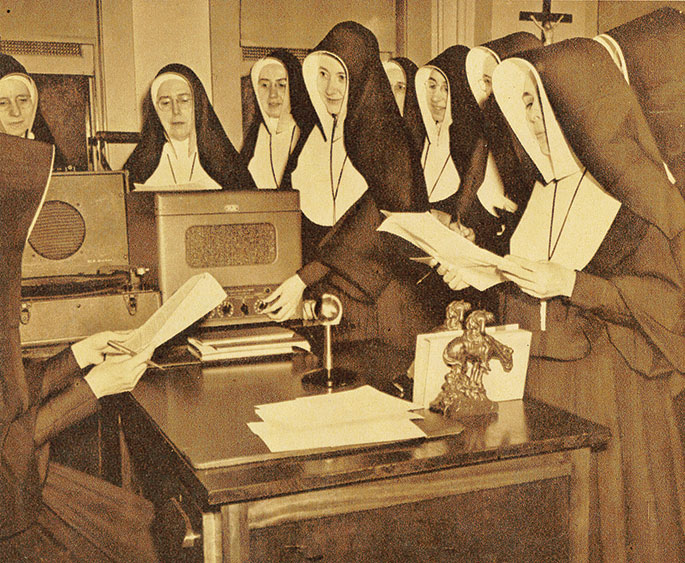 In this photo from August 1952, members of the Sisters of Providence of Saint Mary-of-the-Woods serving as grade school teachers attend a summer course in radio education and script writing at the order’s Saint Mary-of-the-Woods College. The course was created to meet the needs of sisters who had been asked, as part of their teaching assignments, to develop educational material for children to be broadcast on radio. This photo originally appeared in the Terre Haute Tribune­Star. 