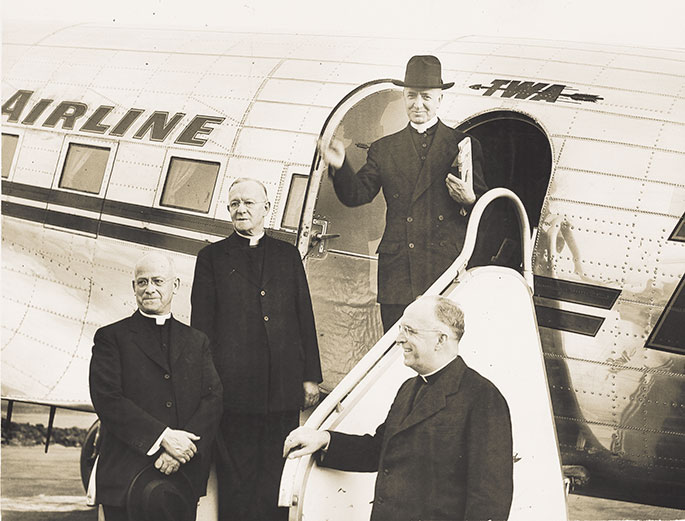 In this photo, Archbishop-designate Paul C. Schulte arrives in Indianapolis after his appointment as archbishop in 1946. Archbishop Schulte was appointed archbishop on July 20, 1946, and arrived in Indianapolis on Oct. 8 of that year. His installation at SS. Peter and Paul Cathedral in Indianapolis was held two days later. He had previously served as bishop of Leavenworth, Kan., beginning in 1937. From left to right in this picture are Msgr. Raymond Noll, archdiocesan vicar general; Msgr. Eugene Vallely, vicar general of the Diocese of Leavenworth; Archbishop Schulte, and Msgr. Henry Dugan, archdiocesan chancellor.