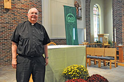 Father John Hall stands on Oct. 10 in St. Anne Church in New Castle. He serves as pastor of St. Anne Parish in New Castle and St. Elizabeth of Hungary Parish in Cambridge City. (Photo by Sean Gallagher)